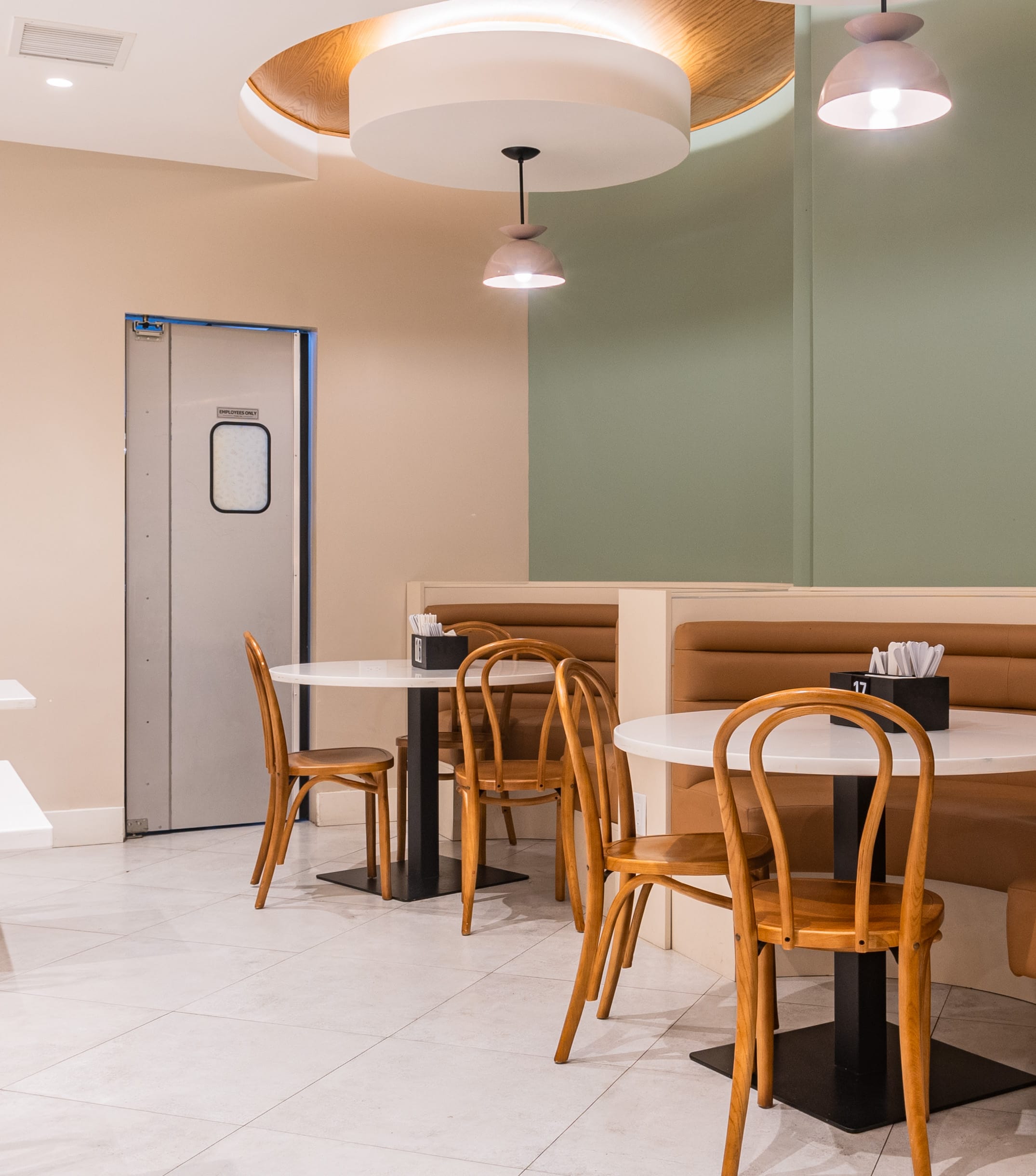 NespoDevelopers-Nov12-8 a room with a booth and tables and chairs